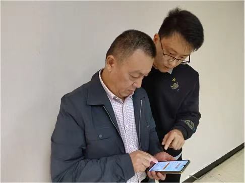 黃太平指導(dǎo)零售客戶線上訂貨。內(nèi)江市煙草專賣局東興區(qū)局（分公司）供圖