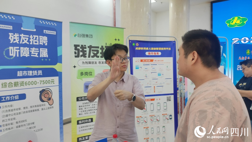 自強(qiáng)集團(tuán)招聘專員用手語與應(yīng)聘殘友溝通。施瑩攝