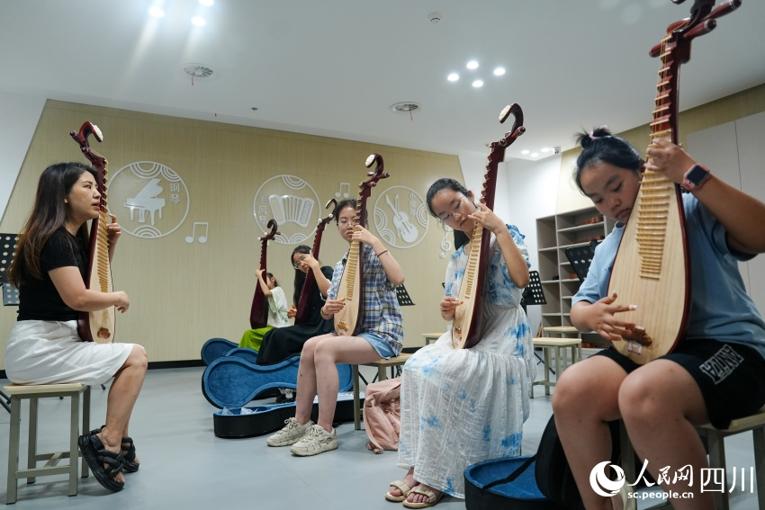 孩子們在眉山市彭山區(qū)文化館“藝啟武陽文化課堂”暑期公益培訓(xùn)班上學(xué)習(xí)琵琶彈奏。翁光建攝