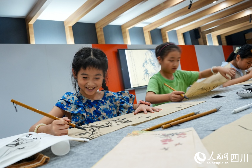 孩子們在眉山市彭山區(qū)文化館“藝啟武陽文化課堂”暑期公益培訓(xùn)班上學(xué)習(xí)中國畫。人民網(wǎng) 趙祖樂攝