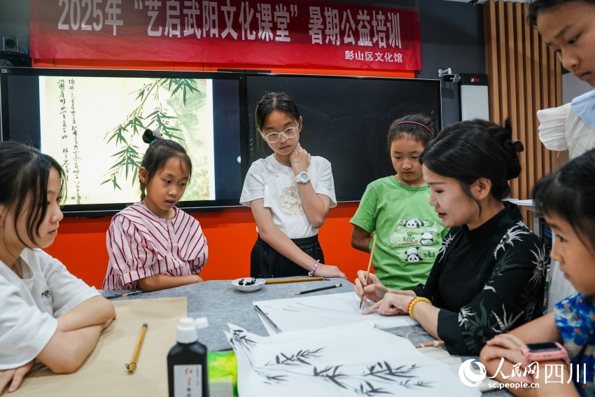 四川大學錦江學院“90后”副教授高子然在眉山市彭山區(qū)文化館為孩子們講解中國畫知識。人民網 趙祖樂攝