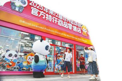 7月14日，游客在世運(yùn)會(huì)官方特許商品零售店紅星路店門口和“蜀寶”打招呼。