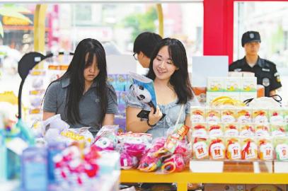 7月14日，游客在官方特許商品零售店紅星路店挑選世運(yùn)會(huì)周邊商品。