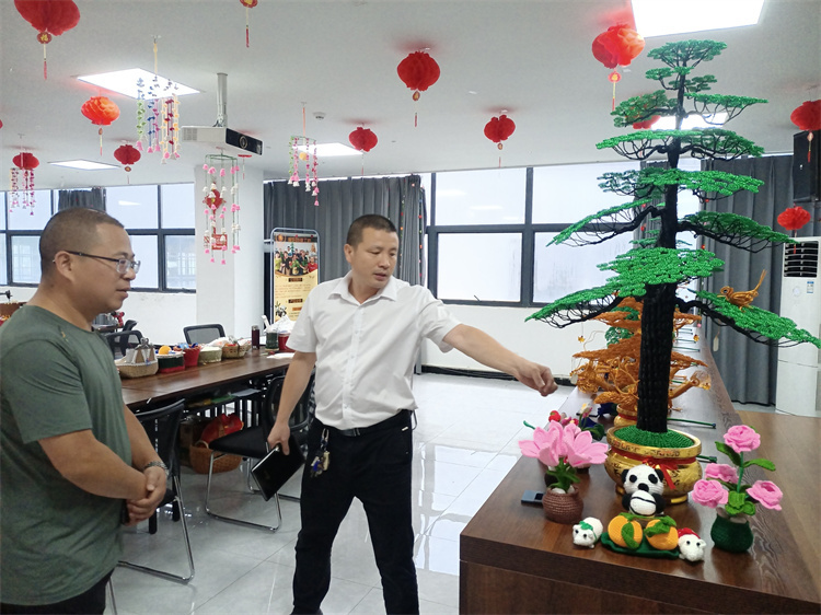 袁其濤（右）向客人介紹產(chǎn)品。劉保剛供圖