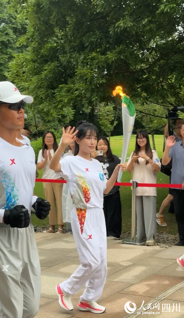 李子柒一邊傳遞一邊向場(chǎng)邊揮手。成都世運(yùn)會(huì)執(zhí)委會(huì)供圖