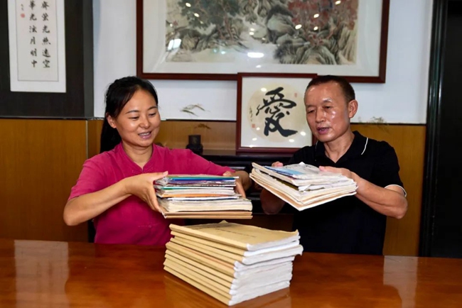 2025年7月30日，王成富和店長(zhǎng)李小娟整理8年來(lái)免費(fèi)人員吃飯登記冊(cè)。劉婷供圖