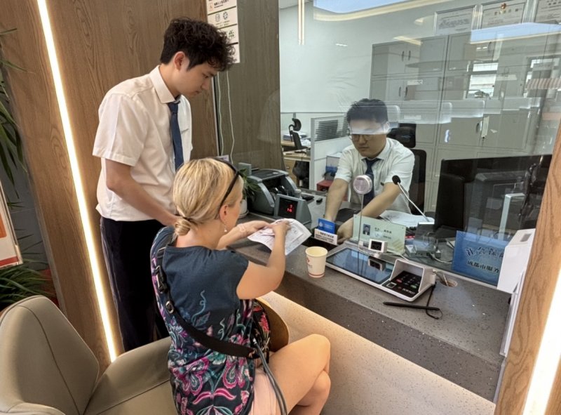 為從波蘭來成都旅游的游客將100美元兌換成人民幣。唐聰攝