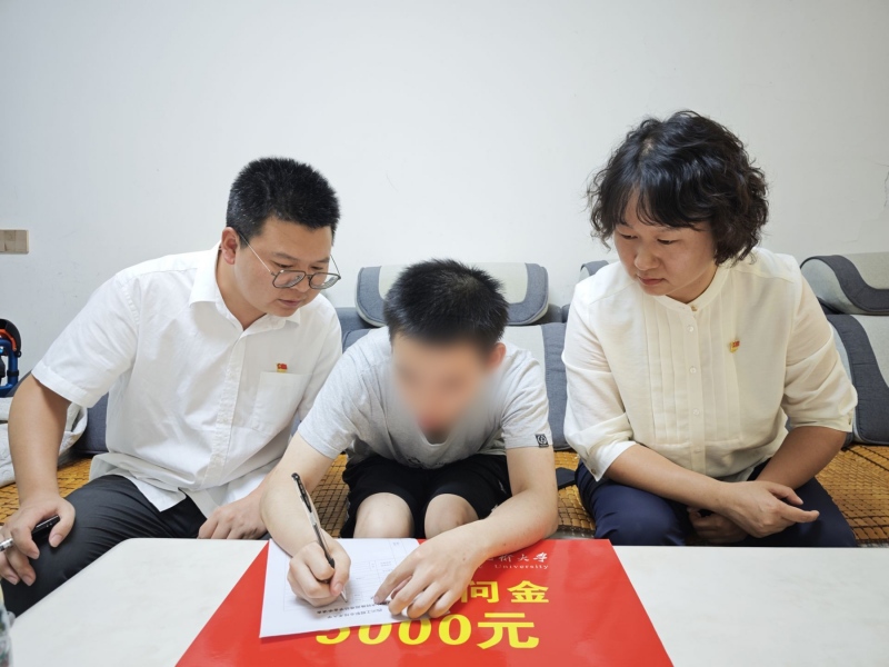 教師代表將助學慰問金交到吳同學手中。四川工程職業(yè)技術(shù)大學供圖