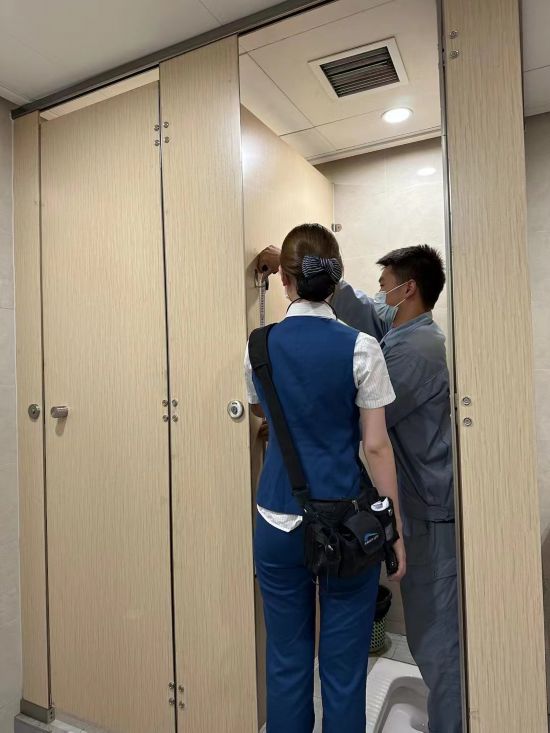 工作人員正在對成都地鐵6號線車站衛(wèi)生間隔間掛鉤進(jìn)行測量。受訪者供圖。