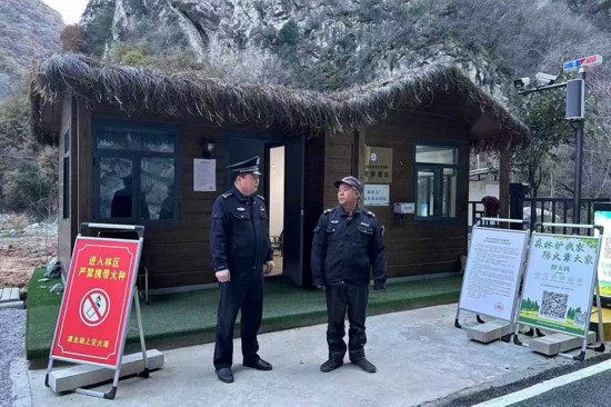 溫軍文（左）在和秦嶺聯(lián)防的民間工作人員交談。李凱攝