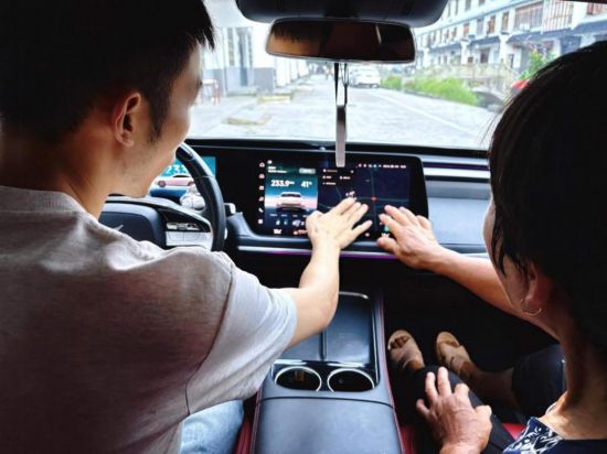 阿豪向村里的老人演示新能源汽車的智能體驗(yàn)。受訪者供圖